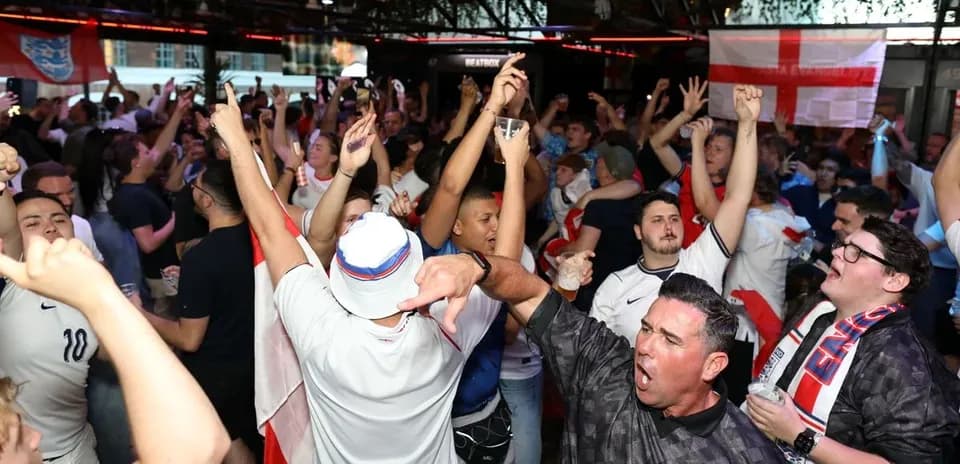 Aficionados celebrando en un bar durante un evento deportivo