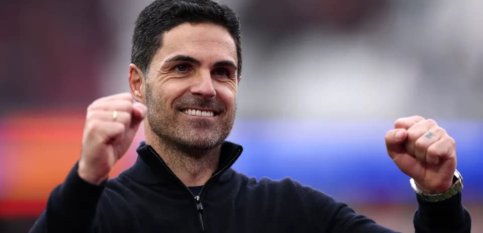Entrenador sonriendo y levantando los puños en señal de victoria