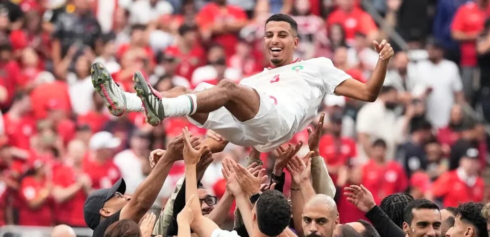 Jugador de Marruecos siendo levantado por aficionados
