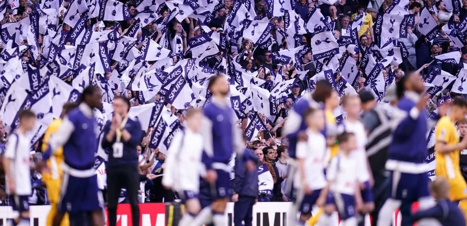Aficionados de Spurs ondeando banderas en el estadio