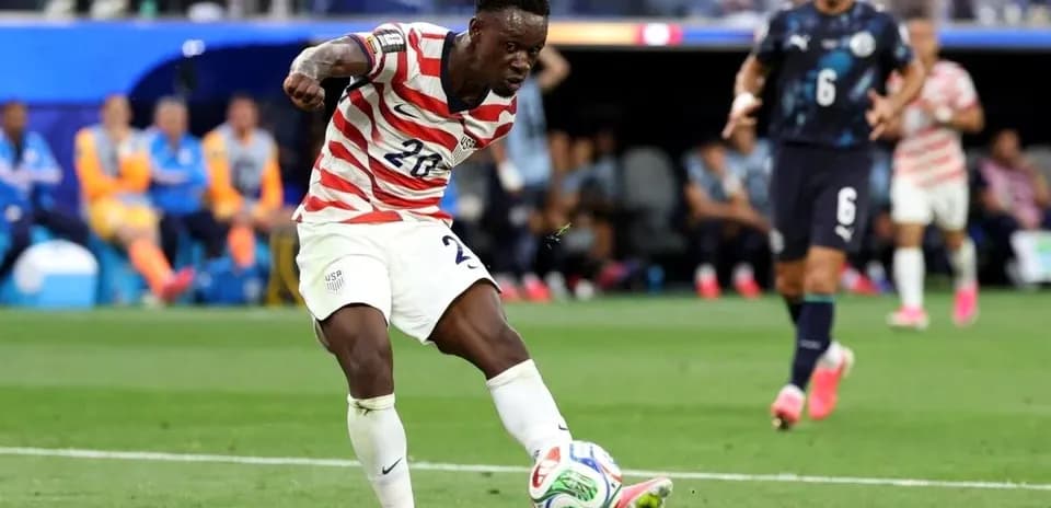 Jugador de Estados Unidos chutando el balón en partido