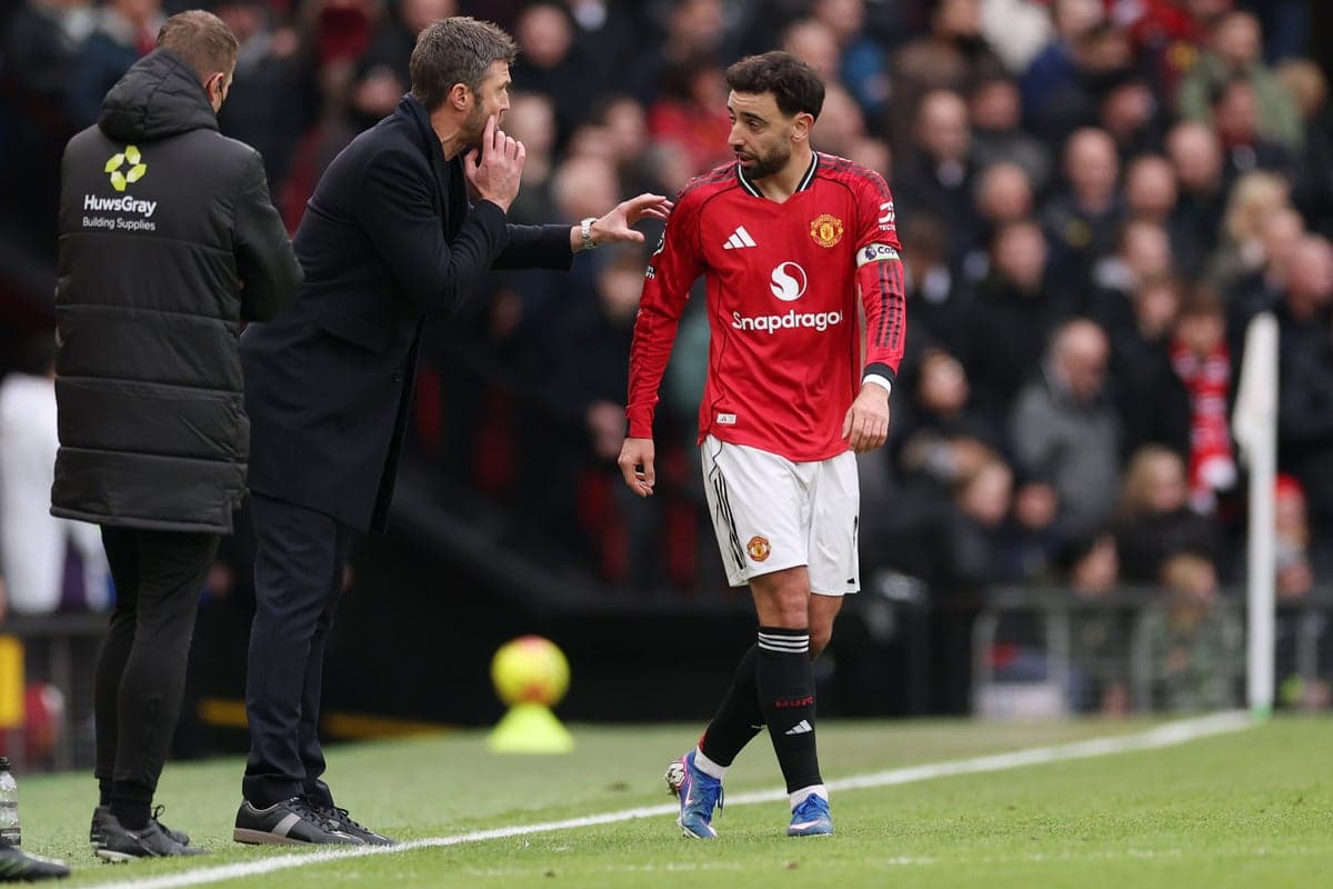 Entrenador dando instrucciones a jugador del Manchester United