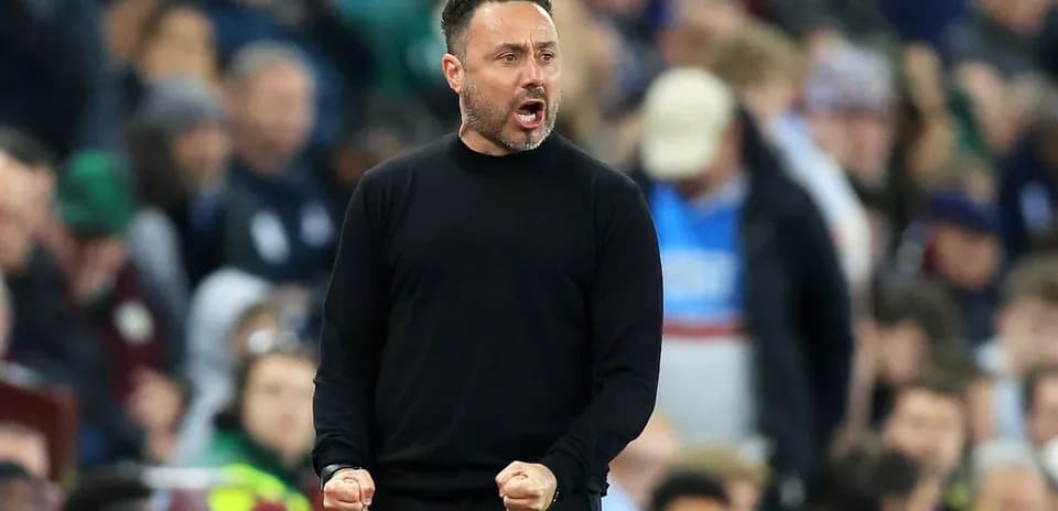 Entrenador celebrando en la línea de banda durante partido