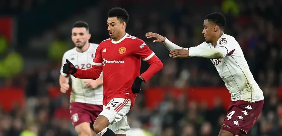 Jugador de Manchester United driblando ante rival de Aston Villa