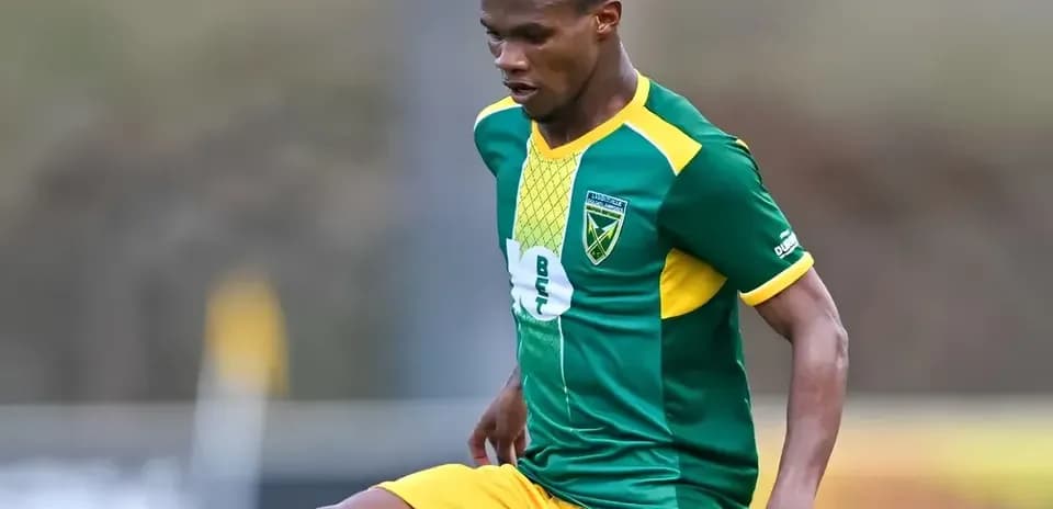 Jugador con uniforme verde y amarillo durante un partido