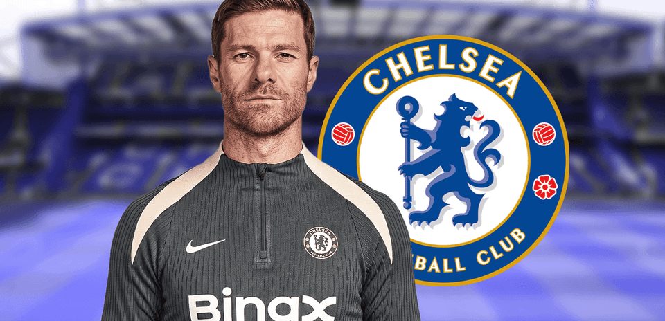 Entrenador posando frente al logo de Chelsea FC