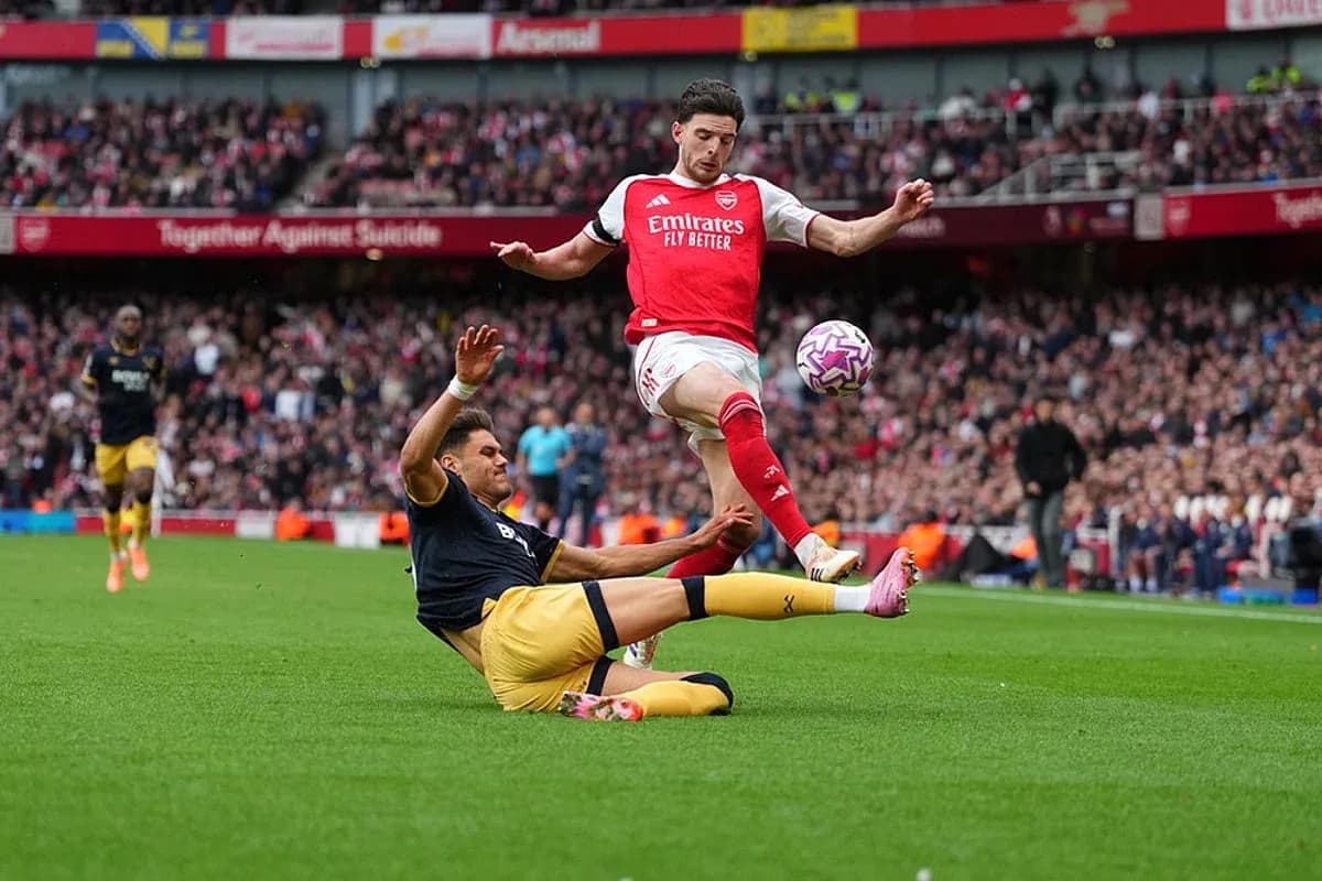 Jugador de Arsenal esquivando a oponente en partido