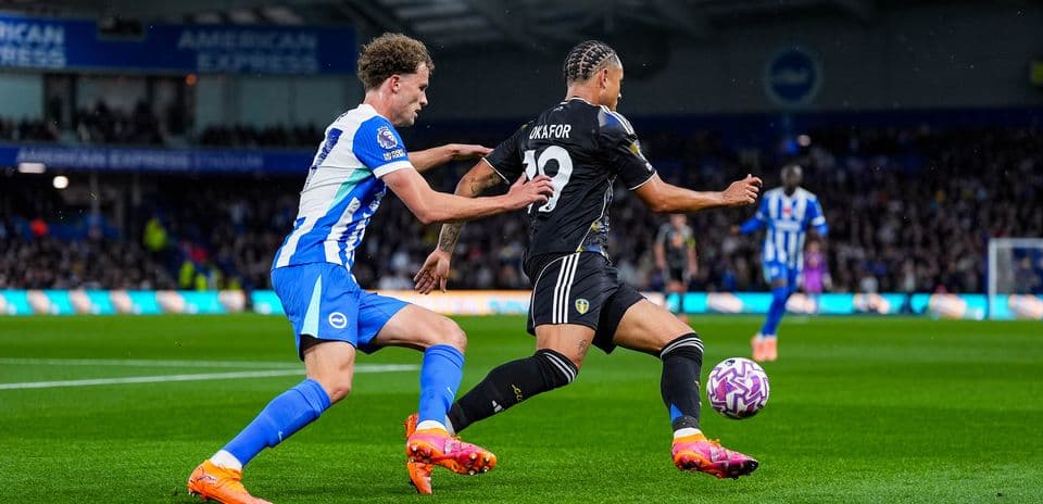 Jugador de Leeds esquivando a defensor de Brighton