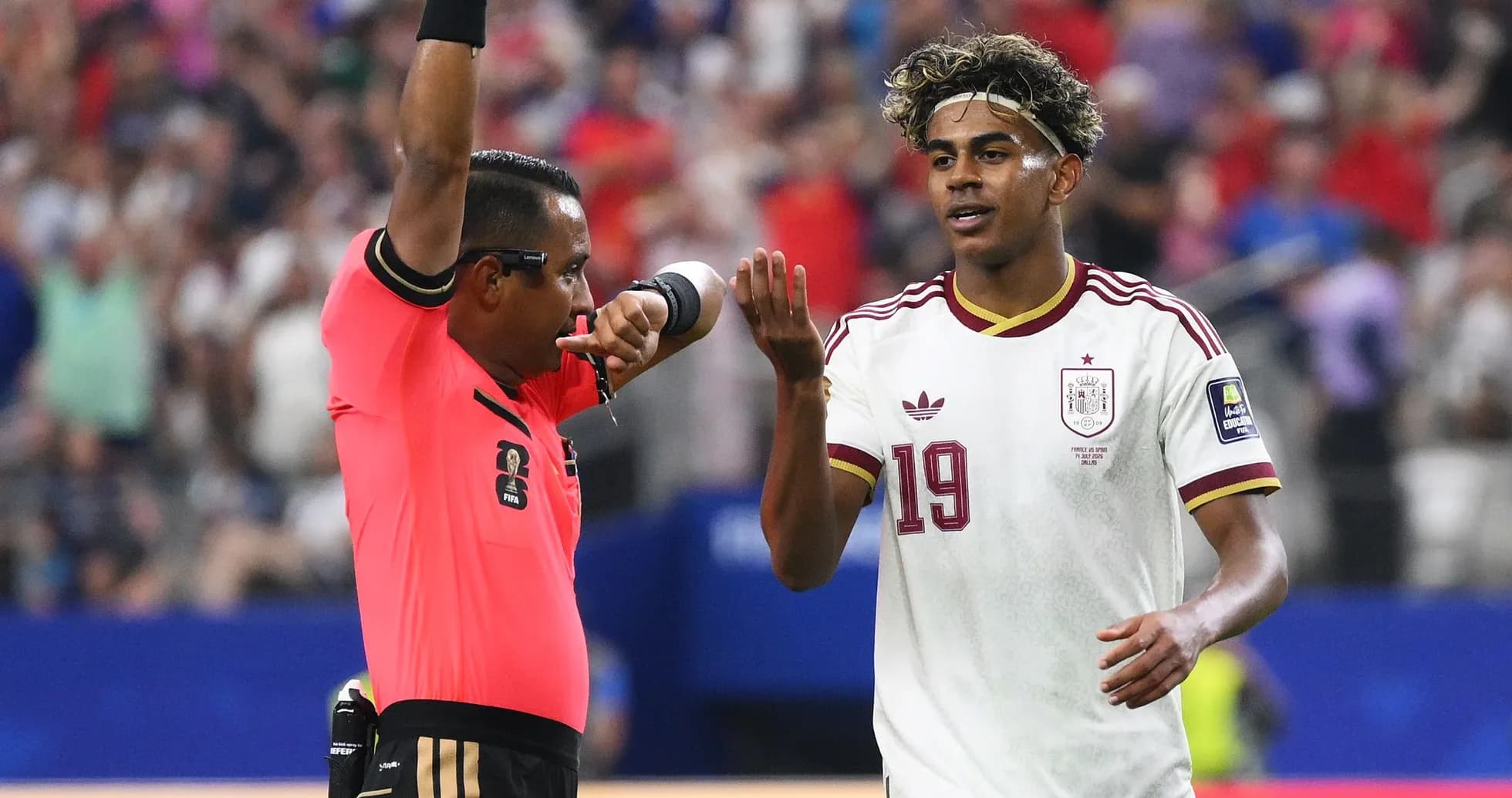 Árbitro mostrando tarjeta mientras jugador reacciona