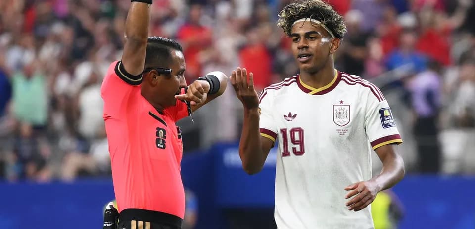 Árbitro mostrando tarjeta mientras jugador reacciona