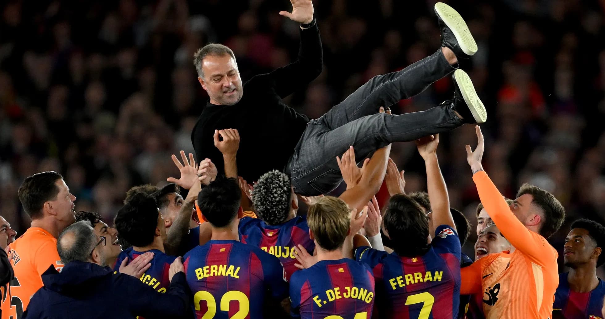 Entrenador siendo levantado por jugadores del Barcelona