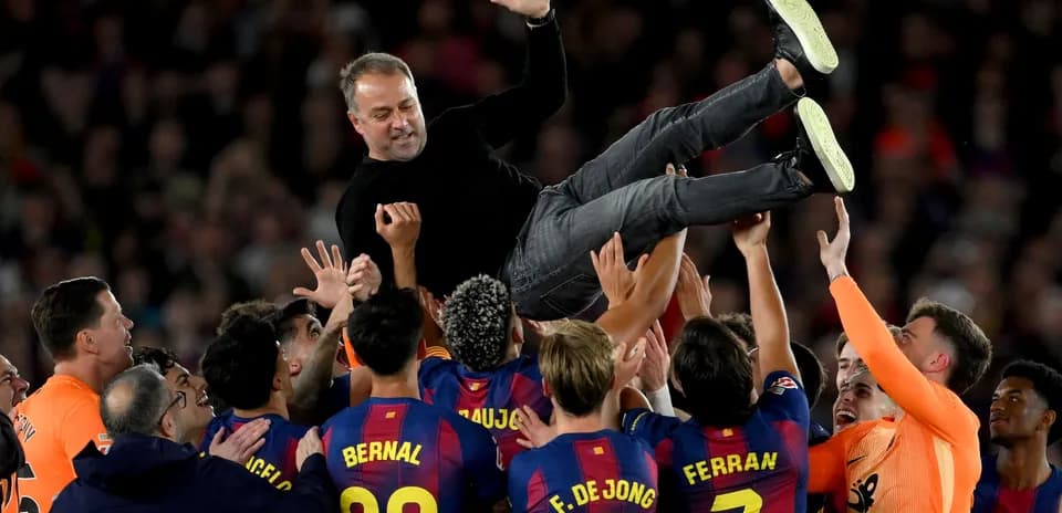 Entrenador siendo levantado por jugadores del Barcelona