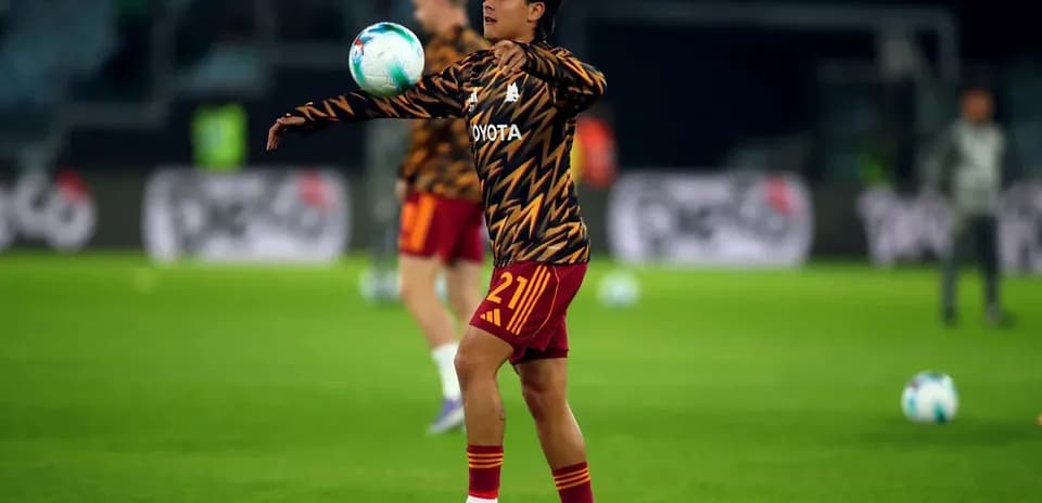 Jugador calentando con balón en campo de fútbol