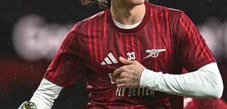 Jugador de Arsenal realizando un estiramiento en el campo