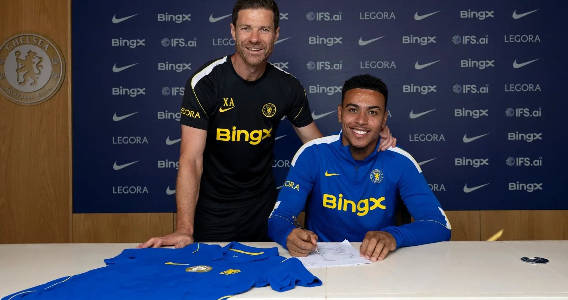 Jugador firmando contrato con entrenador en Chelsea