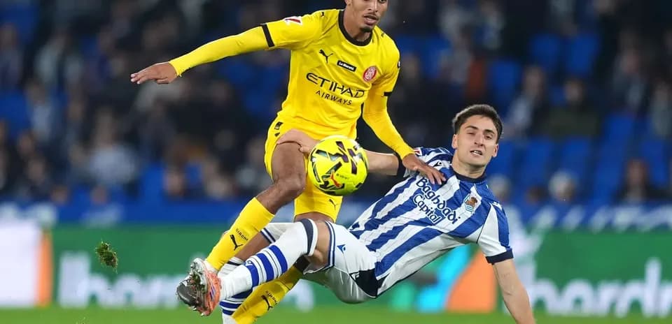 Jugador de Girona enfrentándose a un rival de la Real Sociedad