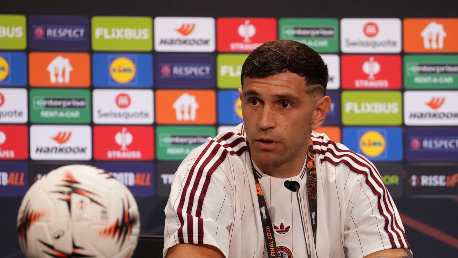 Jugador en conferencia de prensa con balón cerca
