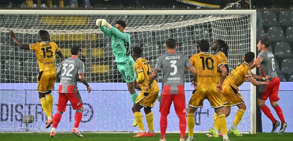 Portero saltando para atrapar el balón en el partido