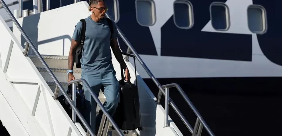 Jugador descendiendo del avión con equipaje