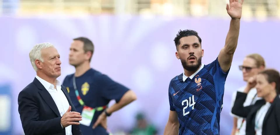 Jugador francés saludando mientras el entrenador observa