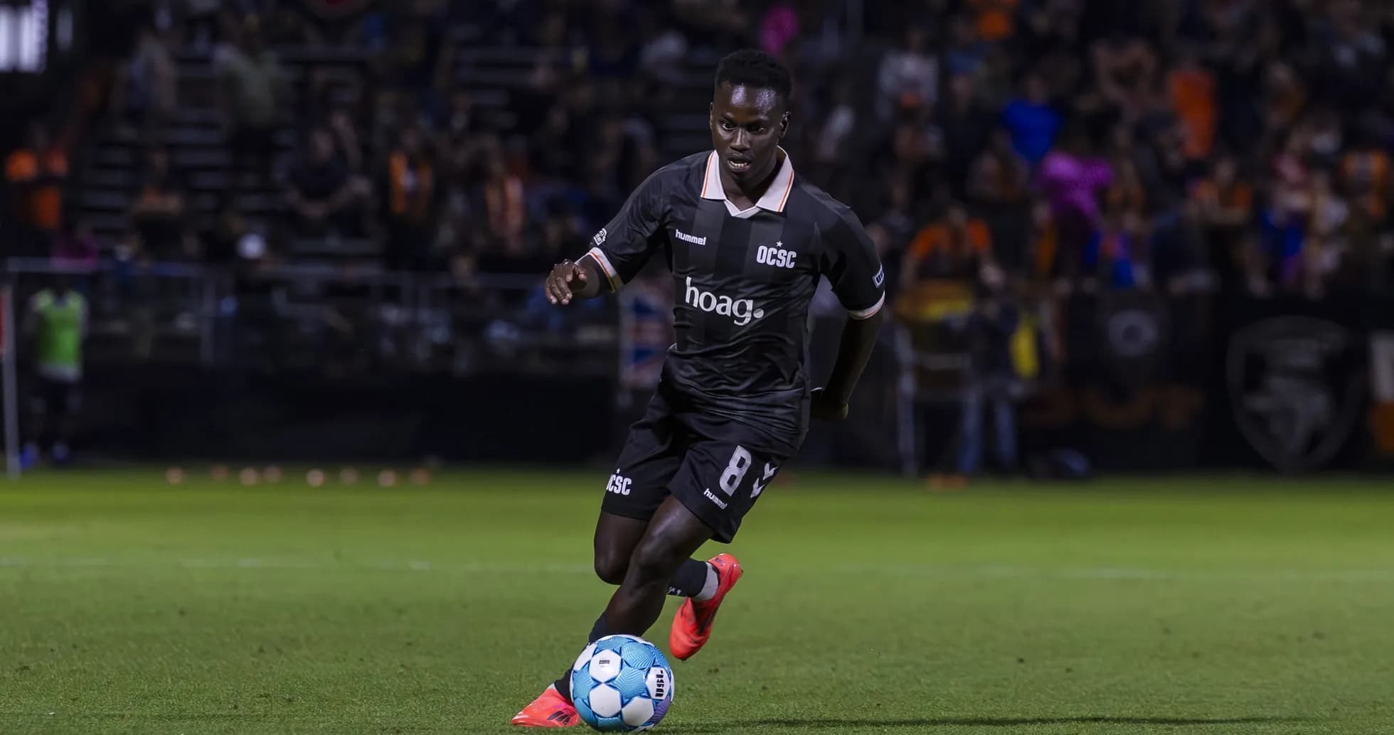 Jugador de Orange County SC corriendo con el balón