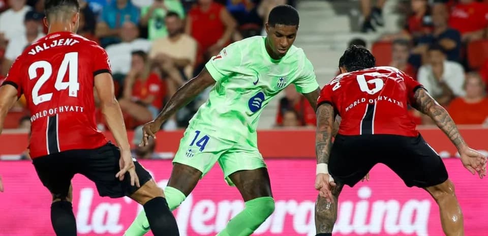 Jugador de Mallorca driblando entre dos defensores