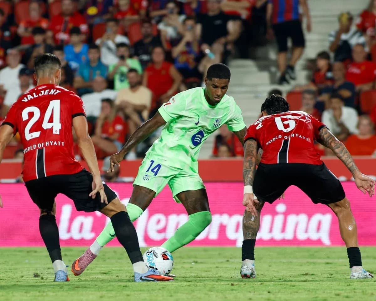 Jugador de Mallorca driblando entre dos defensores