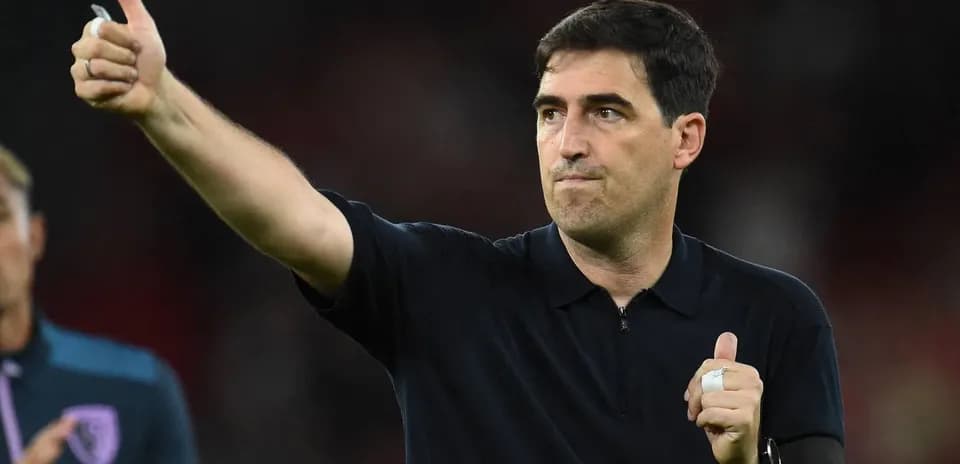 Entrenador señalando con pulgar hacia arriba en el campo