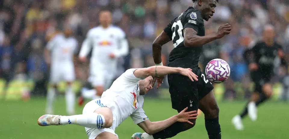 Jugador de Tottenham esquivando a un oponente caído
