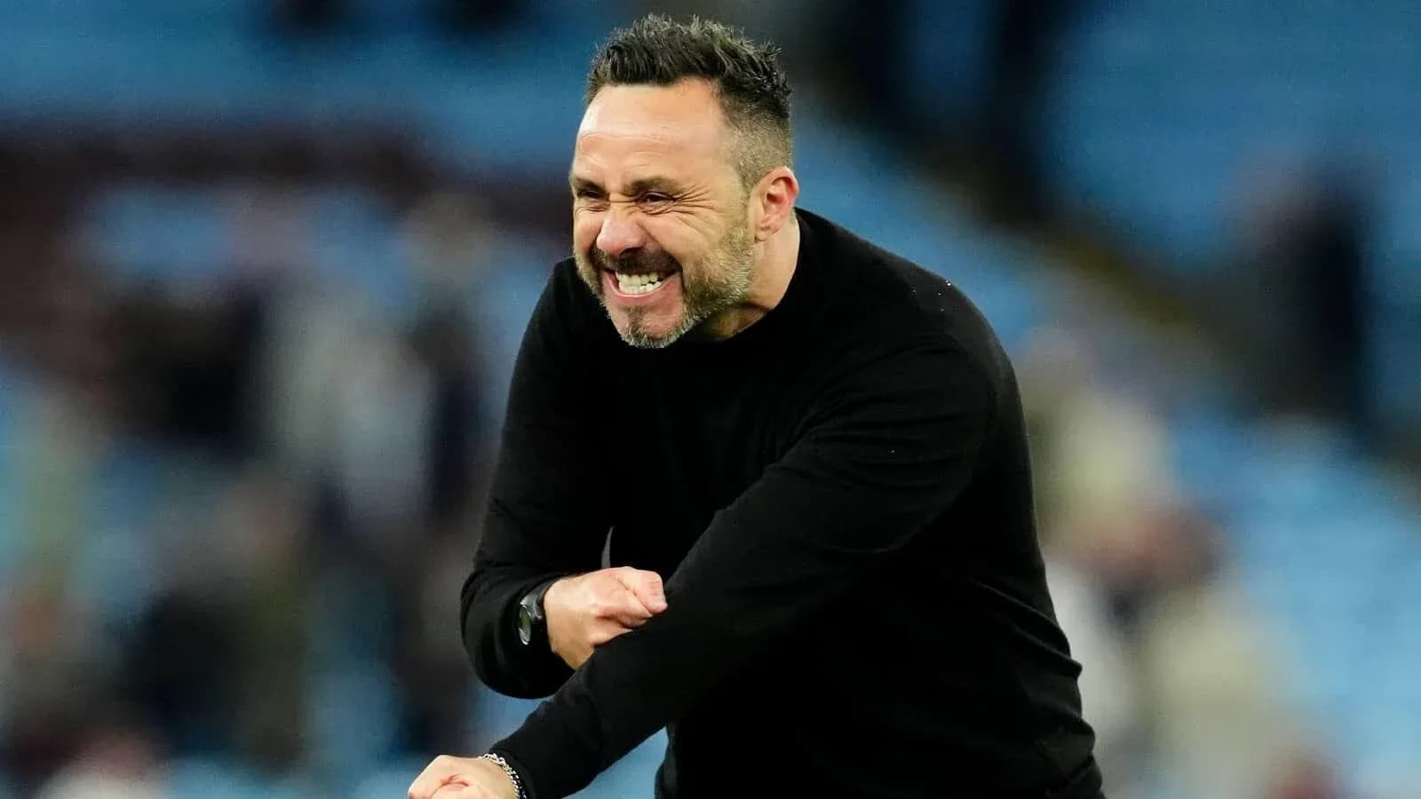 Entrenador celebrando en el banquillo durante partido