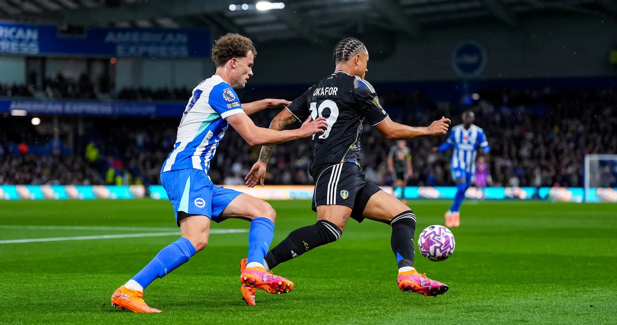Jugador de Leeds intenta escapar de un defensor de Brighton