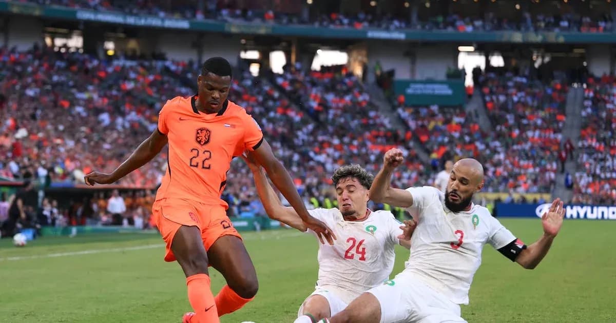 Jugador de Países Bajos driblando entre defensores marroquíes