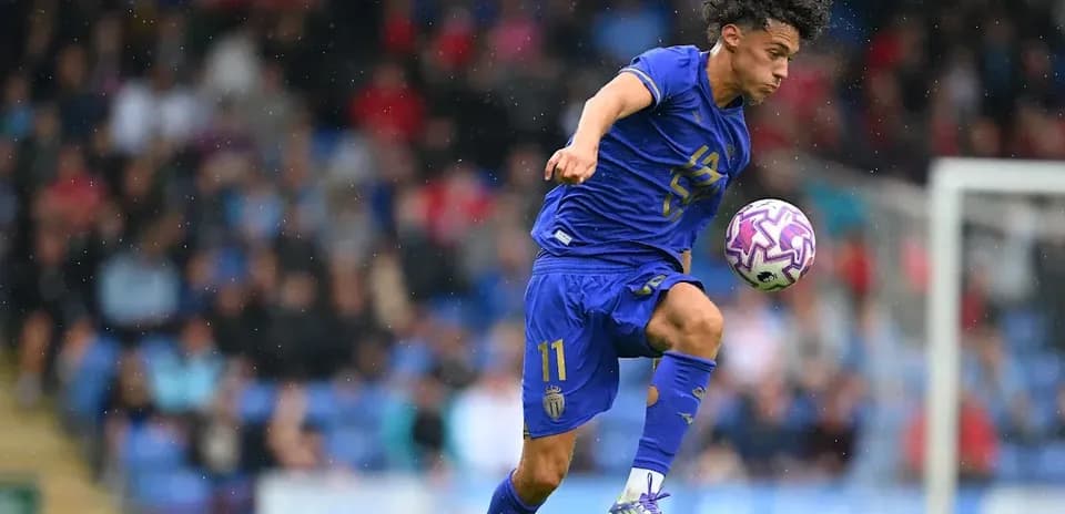 Jugador de fútbol controlando el balón en el aire