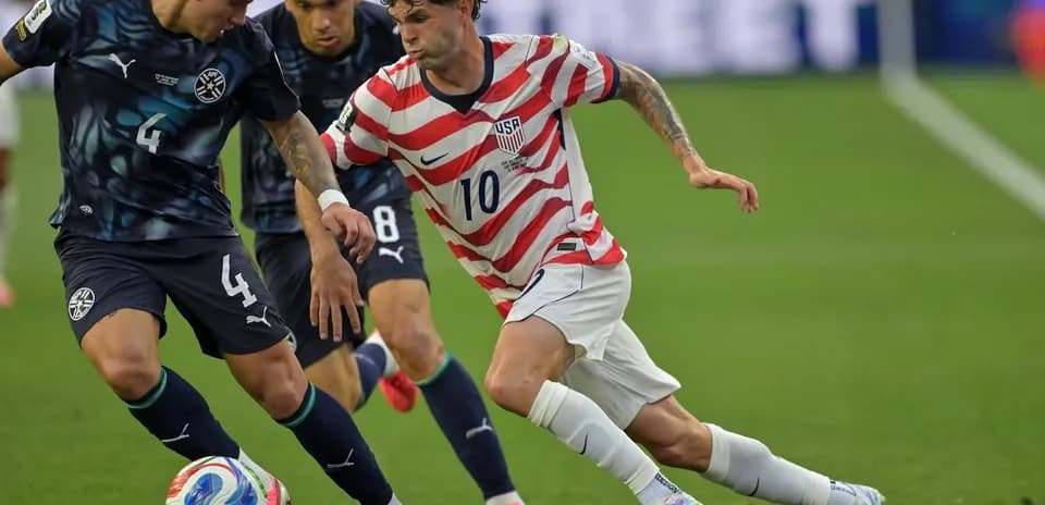 Cristian Pulisic dribbling past defenders during match