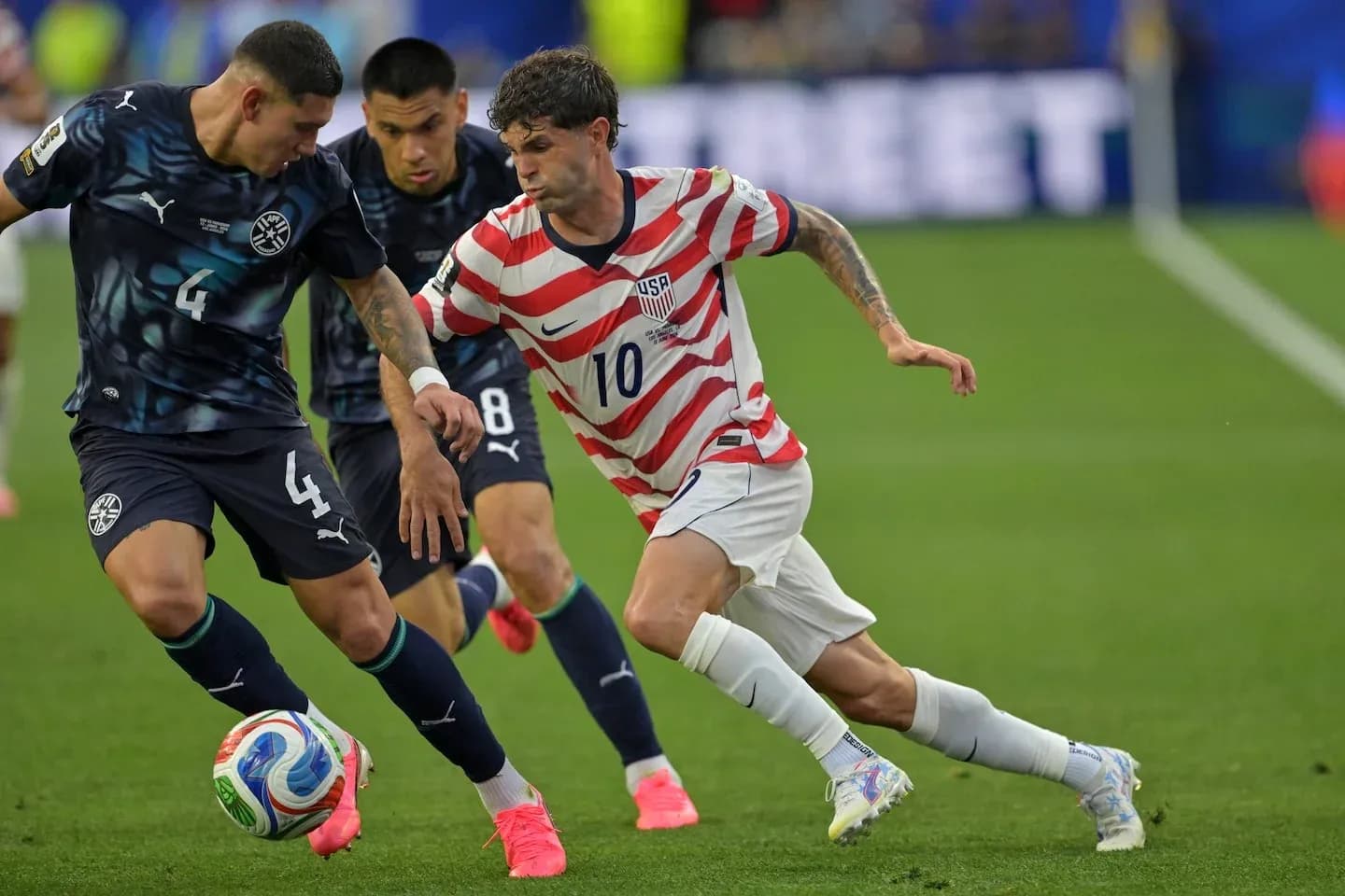 Cristian Pulisic dribbling past defenders during match