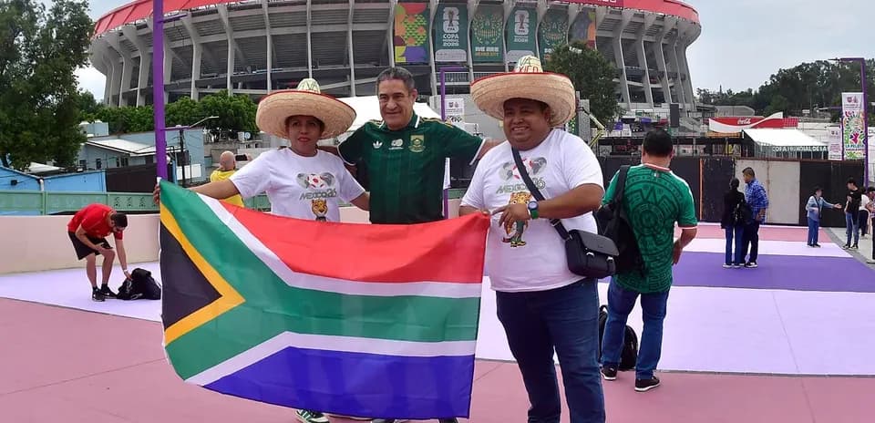 Aficionados sosteniendo bandera de Sudáfrica en el estadio