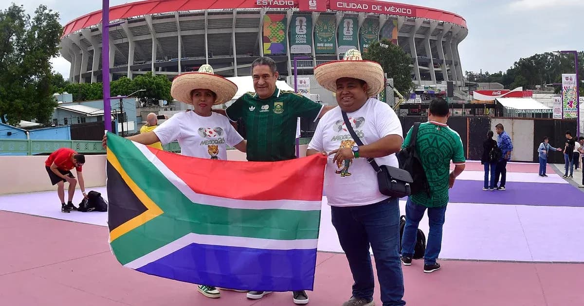 Aficionados sosteniendo bandera de Sudáfrica en el estadio