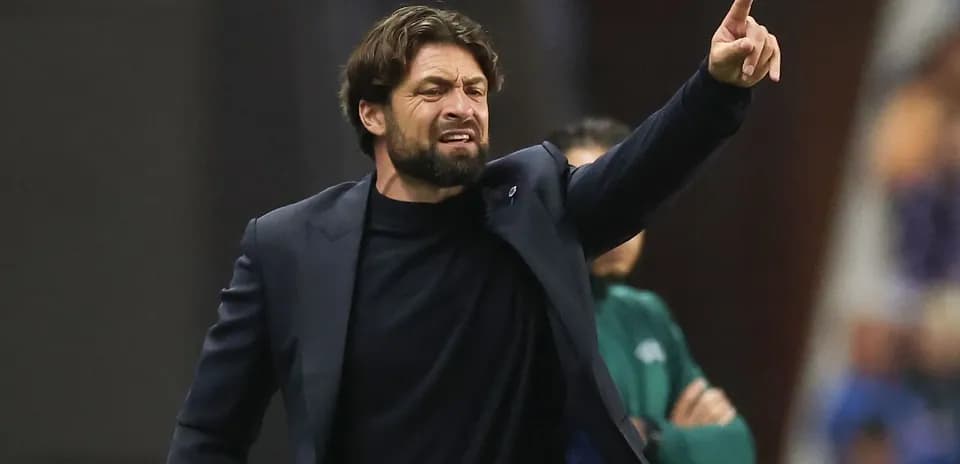 Entrenador dirigiendo al equipo desde la línea de banda