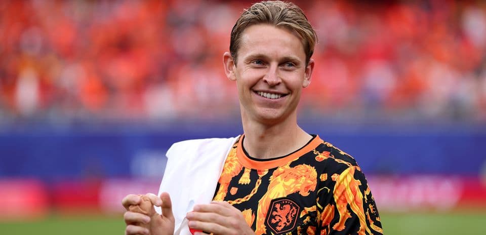 Jugador sonriendo con camiseta naranja en el campo