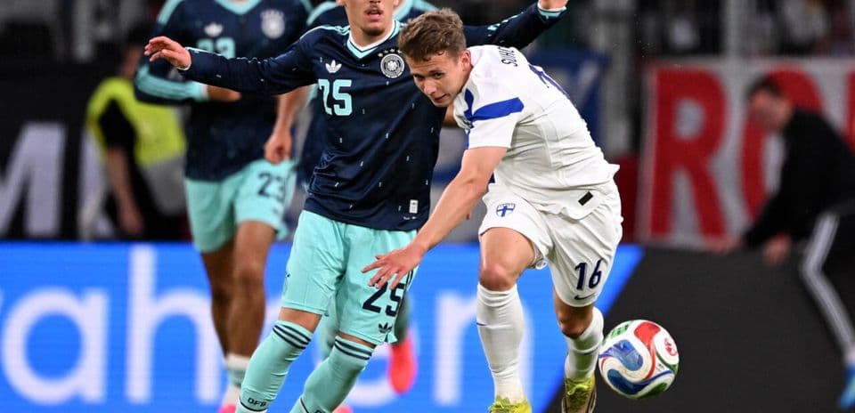 Jugador de Finlandia luchando por el balón con rival