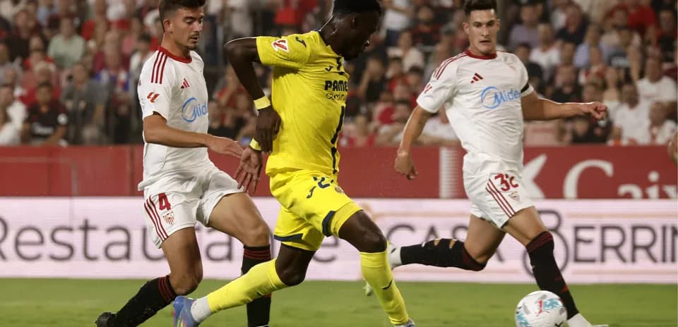 Jugador de Villarreal esquivando a defensores de Sevilla
