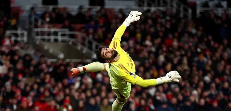 Portero lanzándose para detener el balón en el partido
