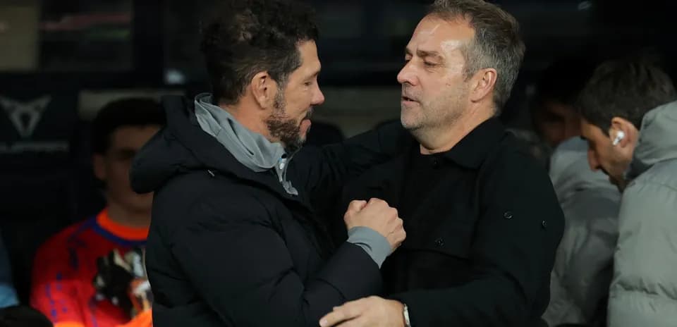 Entrenadores saludándose en el banquillo durante el partido