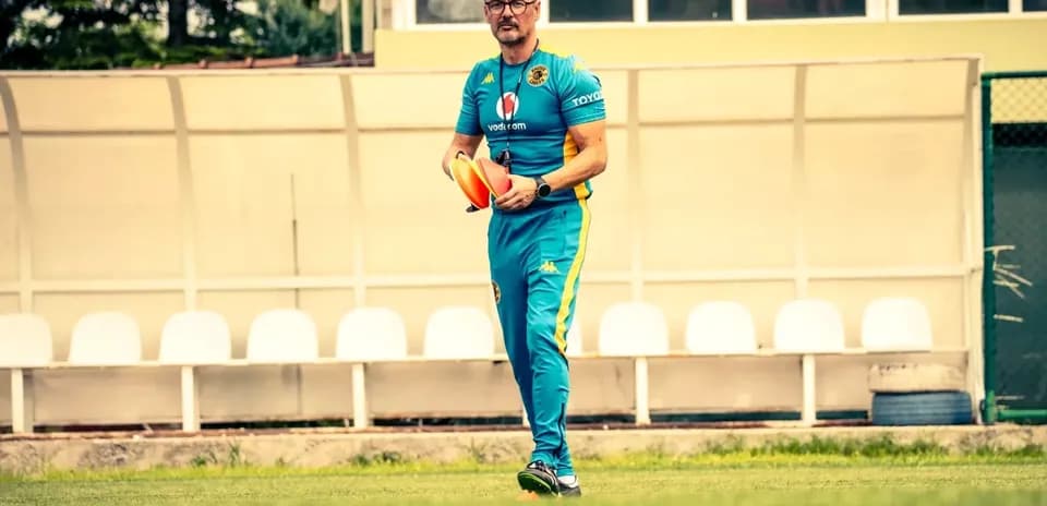 Entrenador sosteniendo conos en el campo de entrenamiento