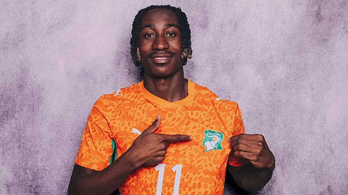 Jugador con camiseta naranja de Côte d'Ivoire señalando escudo