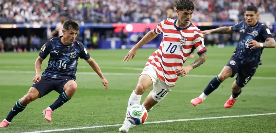 Cristian Pulisic dribbling past defenders in match