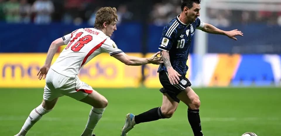 Jugador argentino corriendo mientras es marcado por rival