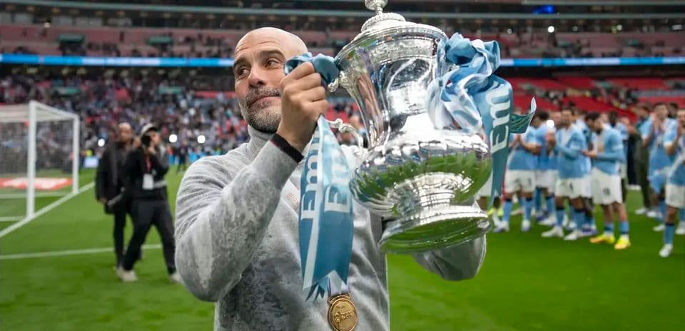 Entrenador sosteniendo el trofeo en Wembley
