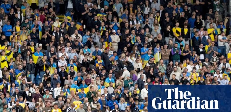 Aficionados animando en un estadio lleno
