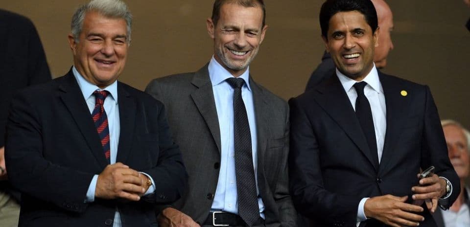Tres dirigentes de fútbol sonriendo en evento